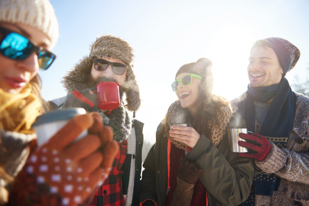 Groupe d’amis dégustant un verre dans un chalet avant de repartir skier