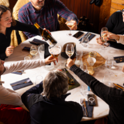 Table conviviale de skieurs levant leur verre de vin et de bière au restaurant
