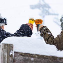 Deux verres de bière trinqués sous la neige – Chalet des Praz La Clusaz