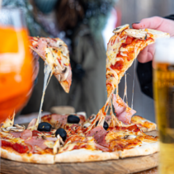 Pizza savoyarde au jambon, champignons et olives servie en terrasse enneigée